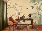 Nursery mural wallpaper with Japanese cranes and floral vines styled above a white baby crib in a neutral room