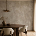 Wabi sabi plaster wallpaper on a living room wall styled with linen furniture and earthy neutral accessories