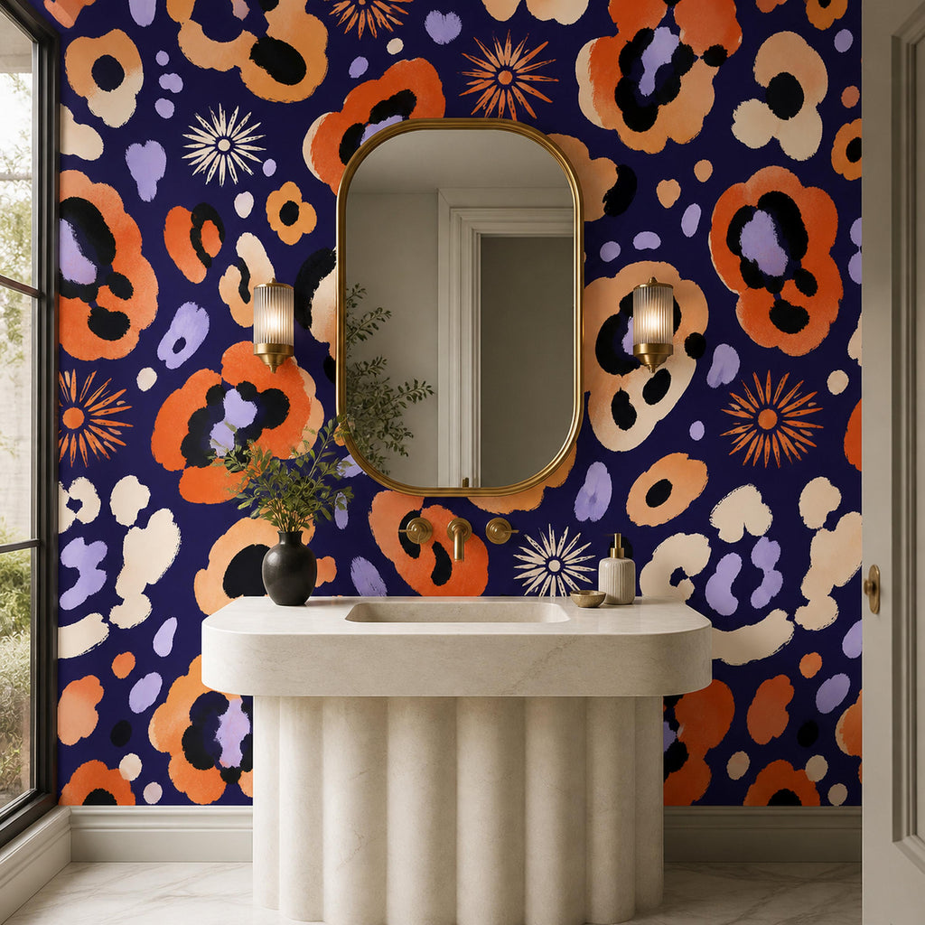 Indigo ocelot leopard print wallpaper in a bathroom with a fluted pedestal sink and gold-framed oval mirror