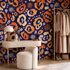 Indigo ocelot leopard print wallpaper in a dressing room with a vanity table, boucle stool and clothing rail