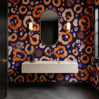 Indigo ocelot leopard print wallpaper in a powder room with a floating stone sink and two wall sconces