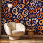 Indigo ocelot leopard print wallpaper in a sitting nook with a cream shell armchair and round side table