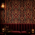 Burgundy Art Deco wallpaper in a lounge with a burgundy velvet banquette and candlelit tables