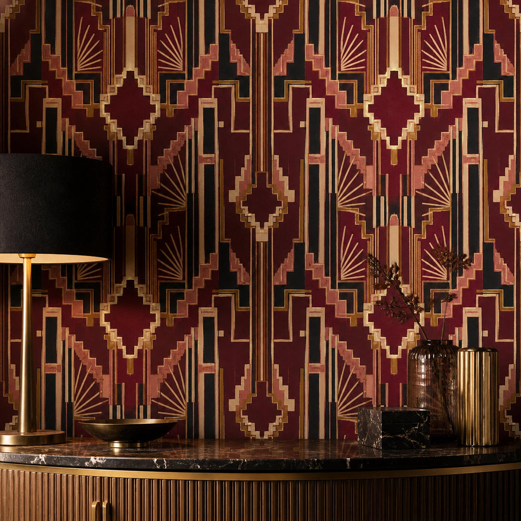 Burgundy Art Deco wallpaper behind a brass lamp with a black shade on a dark marble counter