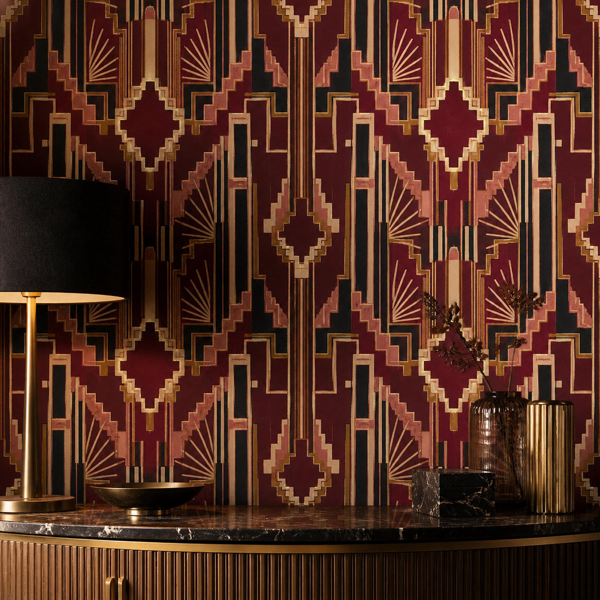 Burgundy Art Deco wallpaper behind a brass lamp with a black shade on a dark marble counter