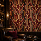 Burgundy Art Deco wallpaper in a study with a leather sofa, red pillow and wooden bookcase