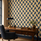 Navy herringbone wallpaper in a home office with a dark wooden desk, brass lamp and navy leather chair