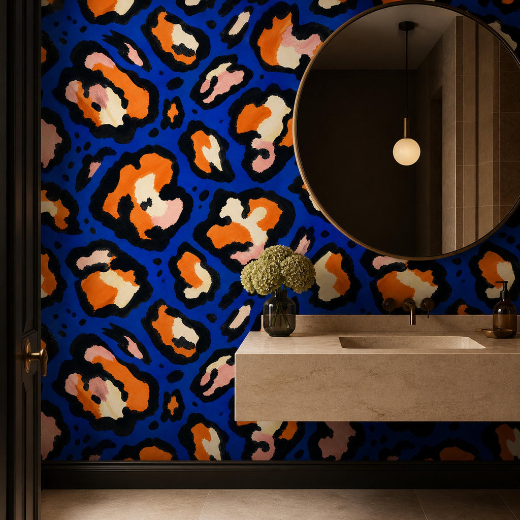 Cobalt leopard wallpaper in a bathroom with a round mirror, floating stone sink and pendant light