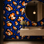 Cobalt leopard wallpaper in a bathroom with a round mirror, floating stone sink and pendant light