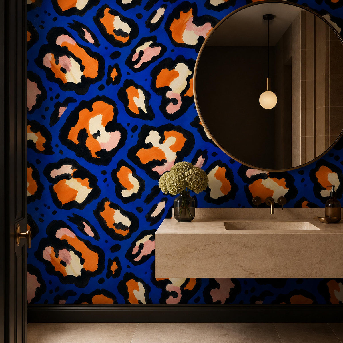 Cobalt leopard wallpaper in a bathroom with a round mirror, floating stone sink and pendant light