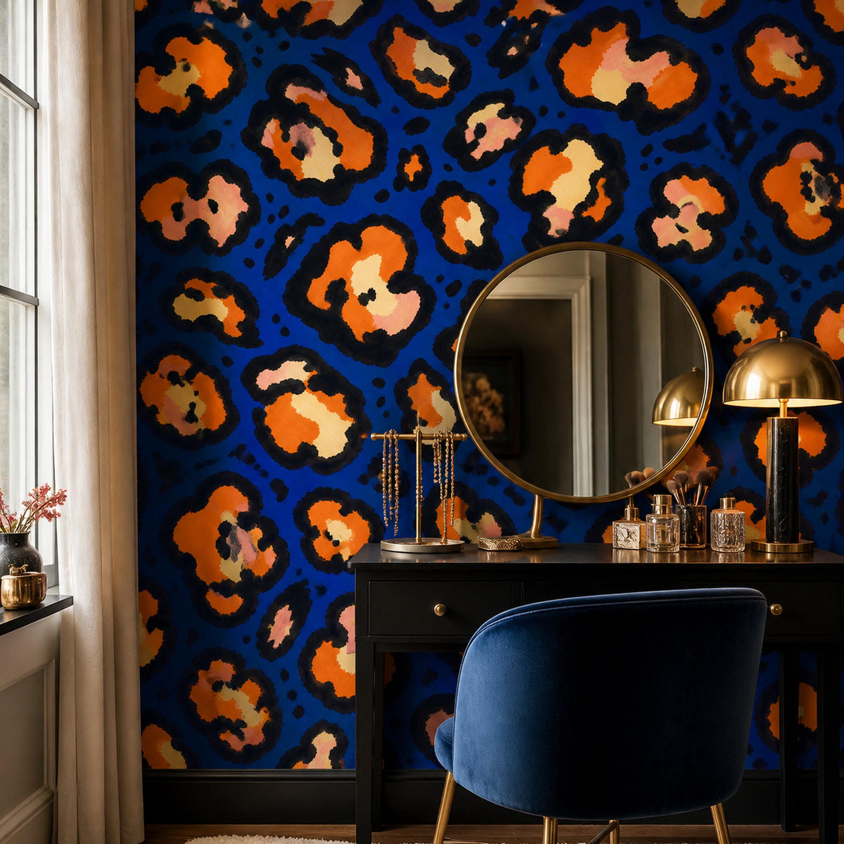 Cobalt leopard wallpaper in a vanity corner with a round mirror, black dresser and navy velvet chair