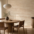 Warm beige travertine peel and stick wallpaper on a dining room accent wall with rattan and wood furnishings