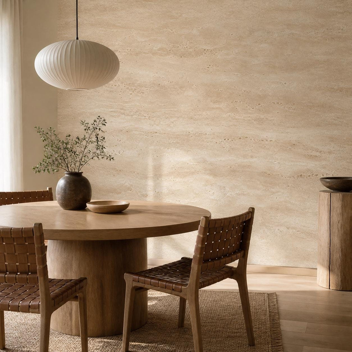 Warm beige travertine peel and stick wallpaper on a dining room accent wall with rattan and wood furnishings