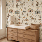 Vintage circus nursery wallpaper above a wooden changing dresser with a basket and table lamp