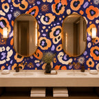 Indigo ocelot leopard print wallpaper in a bathroom with a double vanity, two oval mirrors and folded towels