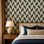 Navy herringbone wallpaper close view of a bed with navy pillows, an upholstered headboard and table lamp