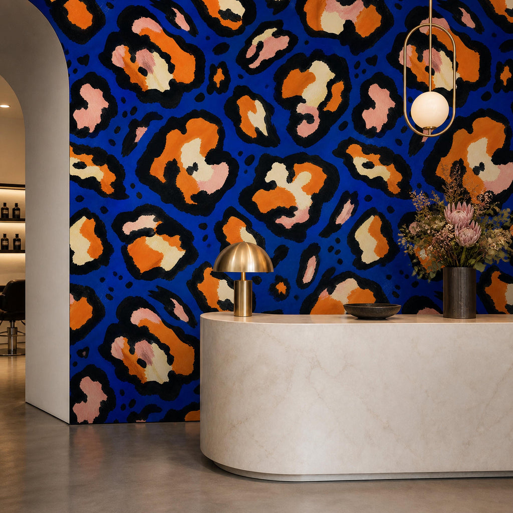 Cobalt leopard wallpaper in a reception area with a curved stone desk and globe pendant
