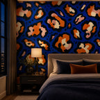 Cobalt leopard wallpaper in a bedroom at night with a table lamp and navy bedding