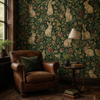 Dark green medieval rabbit wallpaper in a reading corner with a leather armchair and floor lamp