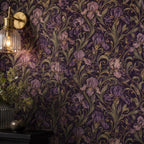 Art Nouveau iris wallpaper close-up of the wall lit by a glass wall sconce beside greenery