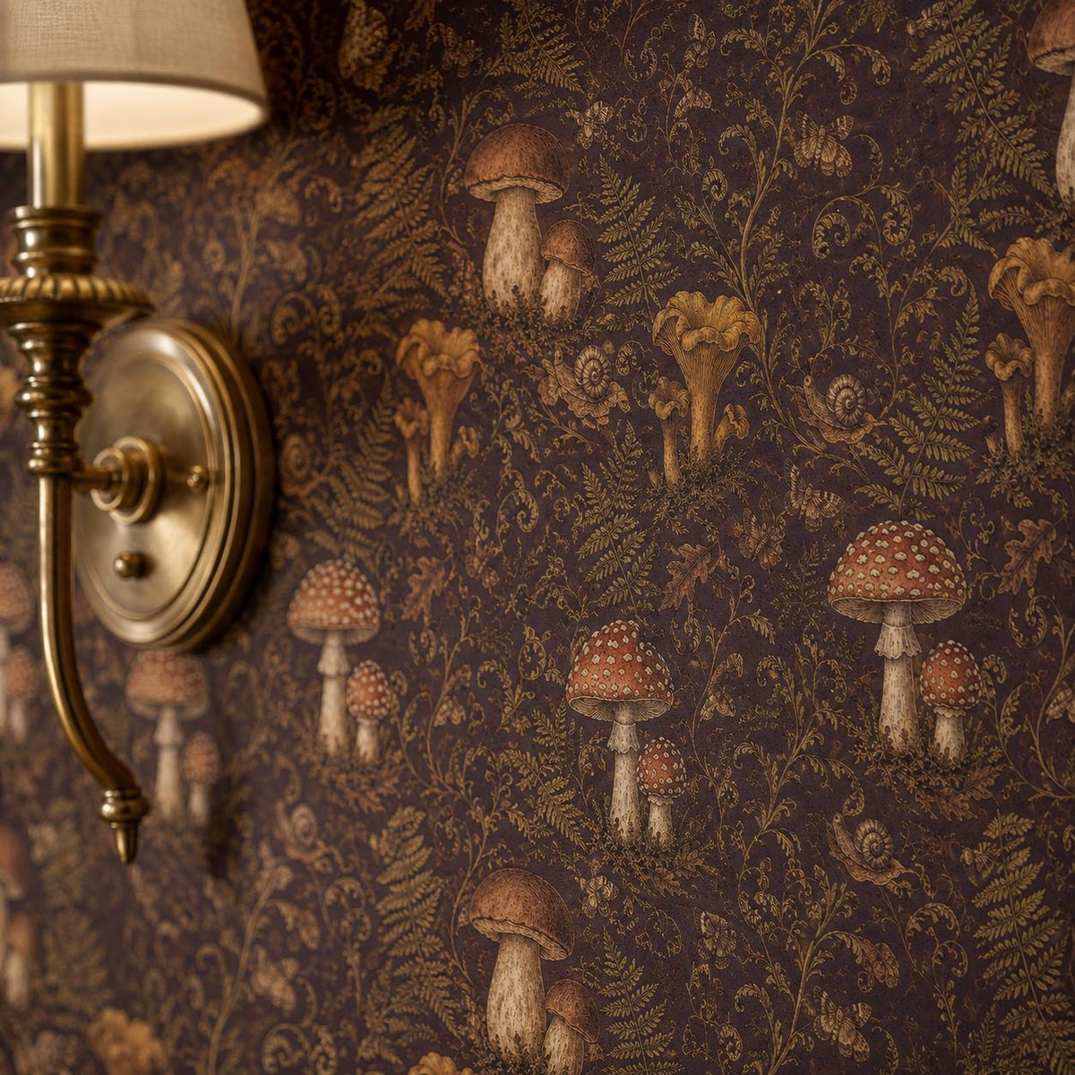 Dark plum mushroom toile wallpaper close-up with a brass wall sconce against the print