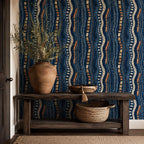 Afrohemian indigo mudcloth wallpaper in an entryway with a rustic wooden console, clay vase and woven basket