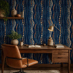 Afrohemian indigo mudcloth wallpaper in a home office with a wooden desk, leather chair and brass lamp