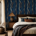 Afrohemian indigo mudcloth wallpaper in a bedroom with a dark wood bed, rust pillows and a patterned throw