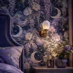 Celestial moon and wisteria wallpaper close-up of the wall beside a purple velvet headboard and wall sconce