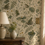 Sage frog botanical wallpaper close-up beside a ceramic table lamp and vase