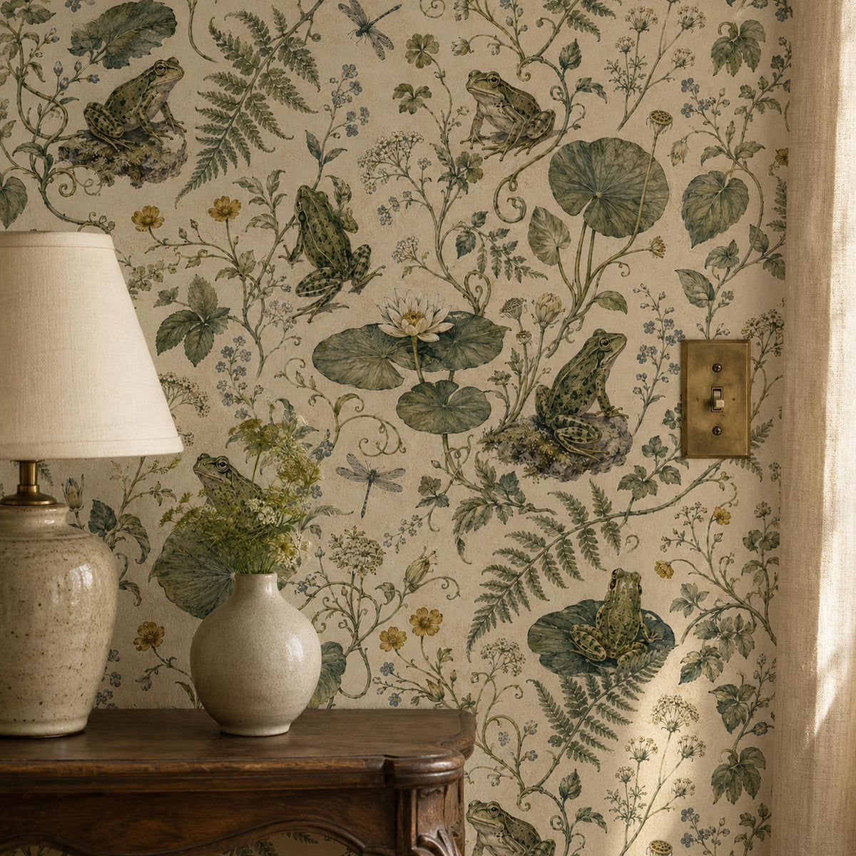 Sage frog botanical wallpaper close-up beside a ceramic table lamp and vase