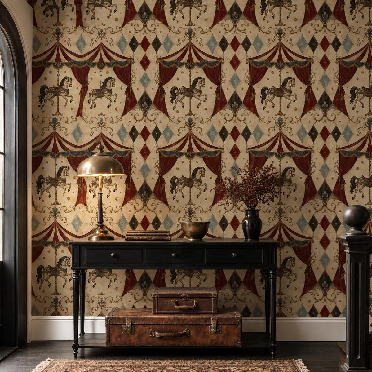 Oxblood harlequin circus wallpaper in a hallway with a black console, brass lamp and vintage suitcase
