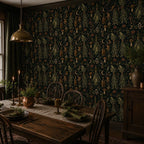 Kitchen witch dark botanical wallpaper in a candlelit dining room with a rustic table and spindle chairs