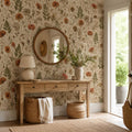 Pressed flower wallpaper in an entryway with a wooden console, round mirror and woven baskets